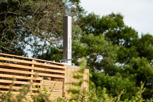 a wooden fence with a pole in front of trees at Kragga Kamma Game Park in Port Elizabeth