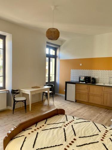 une chambre avec un lit et une table et une cuisine dans l'établissement Villa Baraduc, à Châtel-Guyon