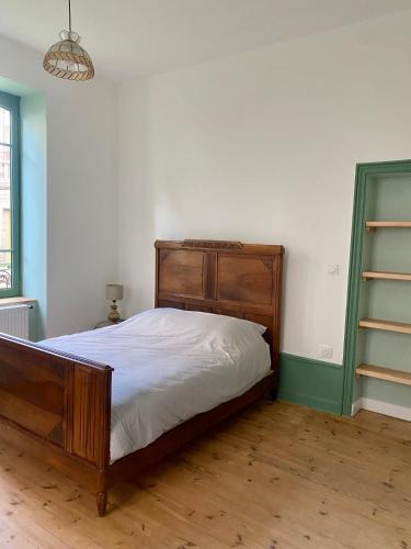 une chambre avec un lit en bois dans une pièce dans l'établissement Villa Baraduc, à Châtel-Guyon