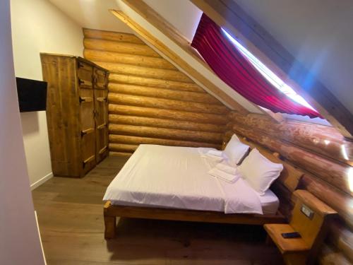 Cabana Repedea في بورشا: غرفة نوم بسرير في غرفة خشبية