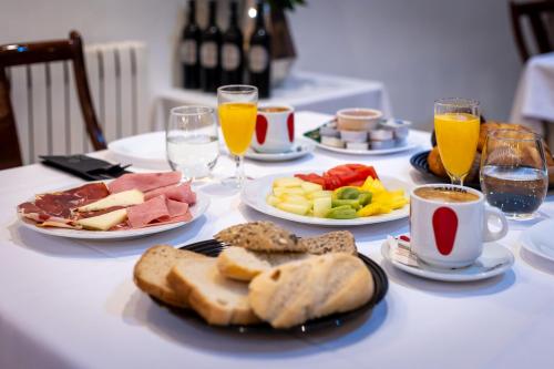 ein Tisch mit Tellern voller Essen und Gläsern mit Orangensaft in der Unterkunft Hostería del Monasterio de San Millan in San Millán de la Cogolla