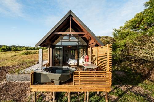 a small house with a hot tub on a deck at Kragga Kamma Game Park in Port Elizabeth