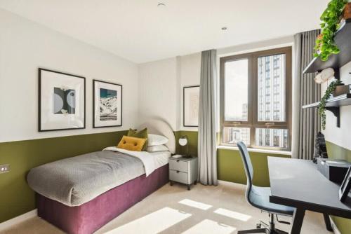 een slaapkamer met een bed en een bureau bij Hestia Residences in Londen