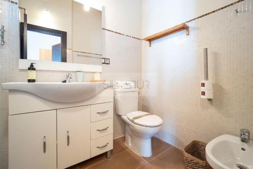 a white bathroom with a sink and a toilet at El Gorin Casona in Gijón