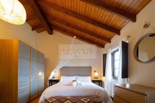 a bedroom with a large bed and a mirror at El Gorin Casona in Gijón