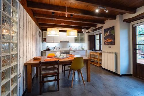 a kitchen with a wooden table and chairs at El Gorin Casona in Gijón