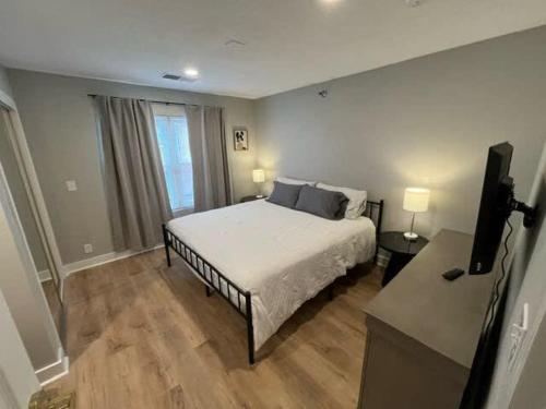 a bedroom with a bed and a television in it at Steps to Aksarben Village, Walk to UNO in Omaha