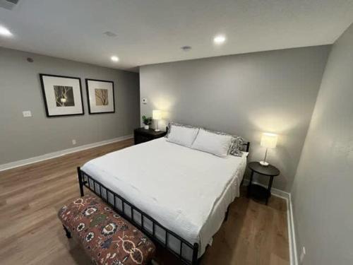 a bedroom with a large white bed and two lamps at Steps to Aksarben Village, Walk to UNO in Omaha