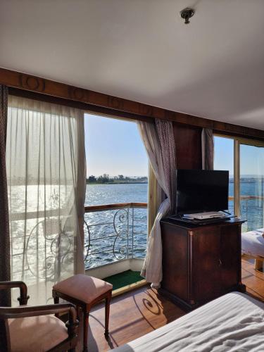 1 dormitorio con ventana grande, cama y escritorio en MS Nile Paradise en El Cairo