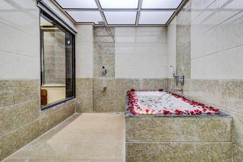 a shower with a tub filled with red hearts at Hotel Apratim Lodging & Boarding in Ambernath