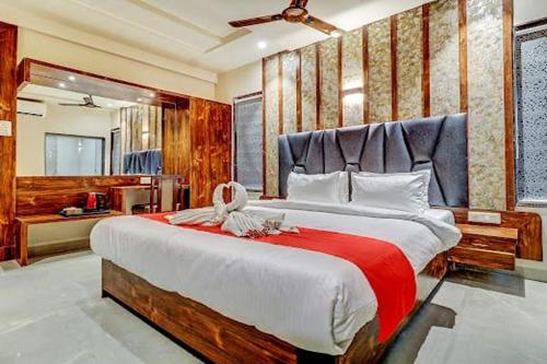 a bedroom with a large bed with a red blanket at Hotel Apratim Lodging & Boarding in Ambernath