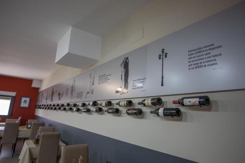 a restaurant with a row of wine bottles on the wall at Hotel LB Villa De Cuenca in Cuenca