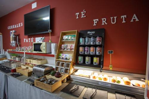 a coffee shop with a counter with food on it at Hotel LB Villa De Cuenca in Cuenca