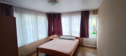 a small bedroom with a bed in front of windows at Отличный отдых на берегу моря in Jūrmala