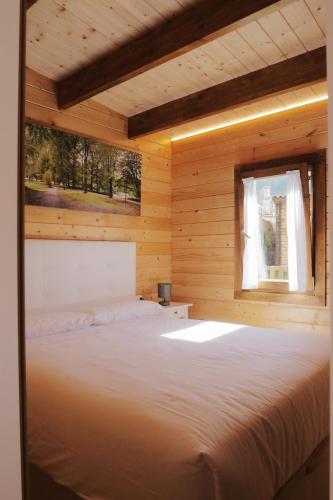 a bed in a wooden room with a window at O Rincón das Rías Baixas in Bueu