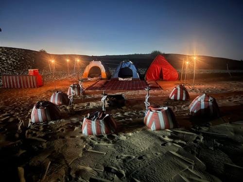 a group of tents in the desert at night at Royal Desert Tourism LLC in Hunaywah