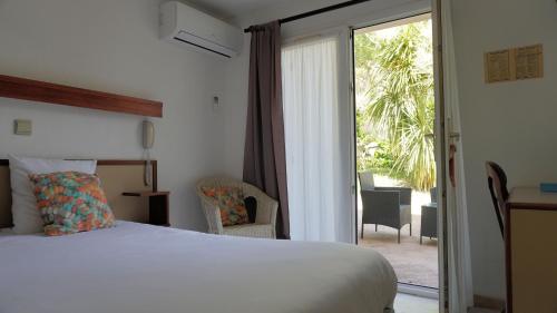 Habitación de hotel con cama y puerta corredera de cristal en Aubergade, en Barbotan-les-Thermes