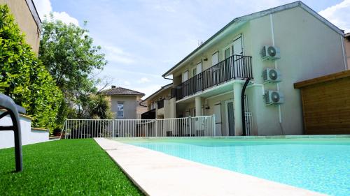 a house with a swimming pool next to a building at Aubergade in Barbotan-les-Thermes
