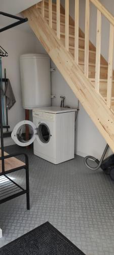 - un lave-linge dans une pièce avec un escalier dans l'établissement Le Ptit Normand entre Ville & Plages, à Loucelles