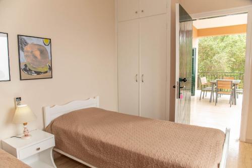 a bedroom with a bed and a balcony with a table at Amalia Complex in Nisakion
