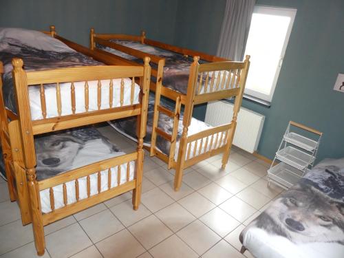 a room with three bunk beds and a window at Coeur de Loup in Sourbrodt