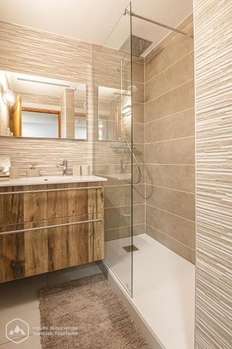 une salle de bain avec une douche en verre et un lavabo dans l'établissement Le Balcon de la Parrachée, à Lanslebourg-Mont-Cenis