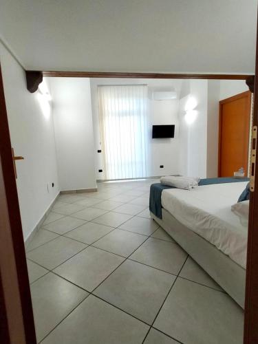 a bedroom with a bed and a tiled floor at Amici in Castellammare di Stabia