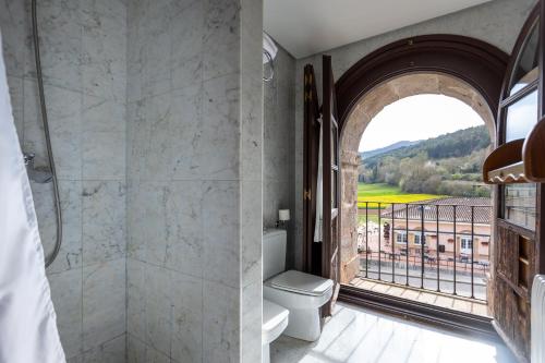 ein Bad mit einer Dusche, einem WC und einem Fenster in der Unterkunft Hostería del Monasterio de San Millan in San Millán de la Cogolla