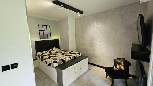 une chambre avec un lit et une chaise dans l'établissement Confidentiel Standing-Climatisé-Parking & Terrasse Privé - Port de Plaisance, à Évian-les-Bains