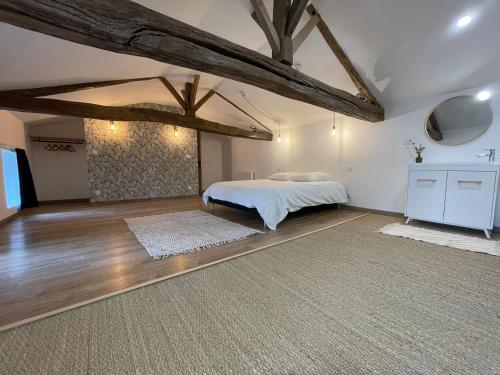 - une chambre avec un lit dans une pièce dotée de poutres apparentes dans l'établissement Maison de Felix, à Saint-Androny