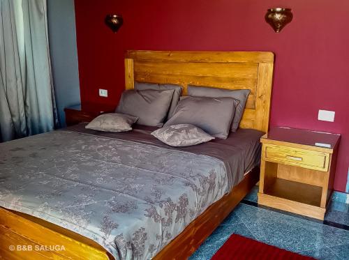 um quarto com uma cama e uma cabeceira em madeira em B&B Saluga Sehel Island Nubian House em Aswan