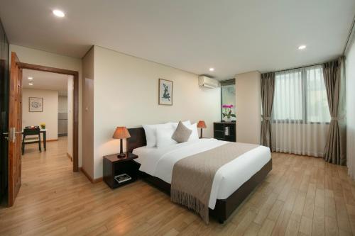 ein Schlafzimmer mit einem großen weißen Bett in einem Zimmer in der Unterkunft HB Serviced Apartment - 121B Quan Hoa in Hanoi