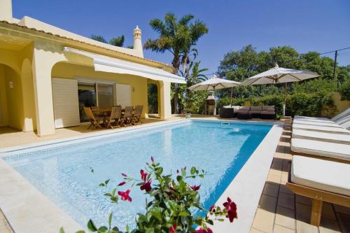 eine Villa mit einem Pool und einem Haus in der Unterkunft Villa Jasmim in Almancil