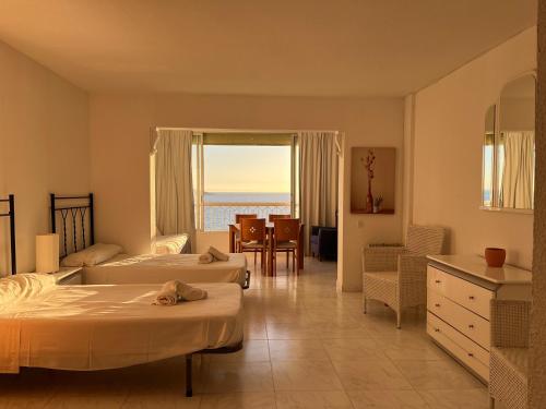 een hotelkamer met twee bedden en uitzicht op de oceaan bij Gestión Inmobiliaria Carmona Rent in Benidorm