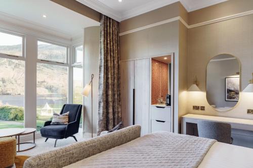 a bedroom with a bed and a chair and a table at The Inn On The Lake in Glenridding