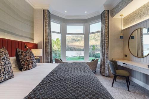a bedroom with a large bed and a mirror at The Inn On The Lake in Glenridding