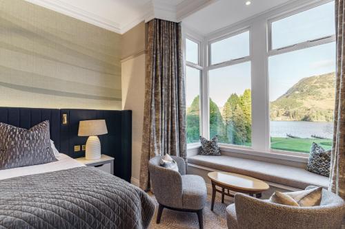 a bedroom with a bed and a large window at The Inn On The Lake in Glenridding