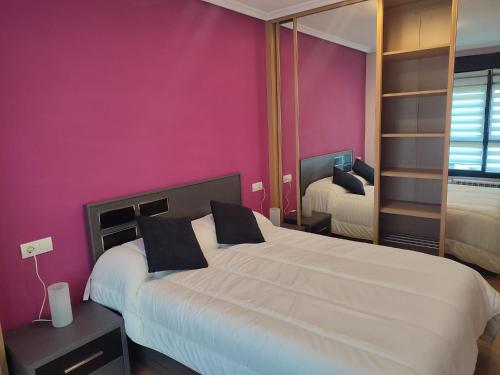 1 dormitorio con cama grande y pared morada en Apartamento Florida-Natura Oviedo, en Oviedo