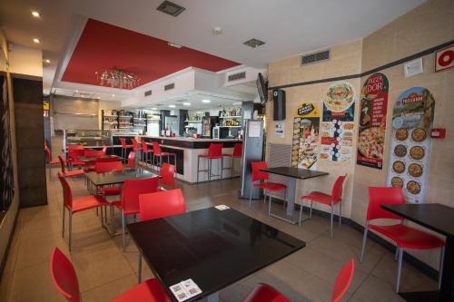 a fast food restaurant with tables and red chairs at Hotel LB Villa De Cuenca in Cuenca