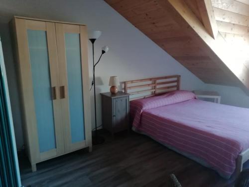 1 dormitorio con 1 cama y vestidor con lámpara en Mansarda Arel, en Turín