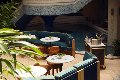 a restaurant with two tables and chairs and a staircase at Mayfair House Hotel & Garden in Miami