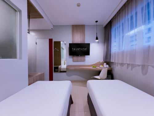 a hospital room with two beds and a desk at favehotel Gatot Subroto Jakarta in Jakarta
