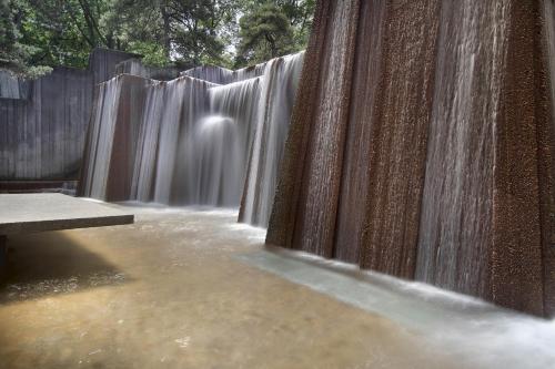 a waterfall in front of a wooden fence at Silver Cloud Hotel - Portland in Portland