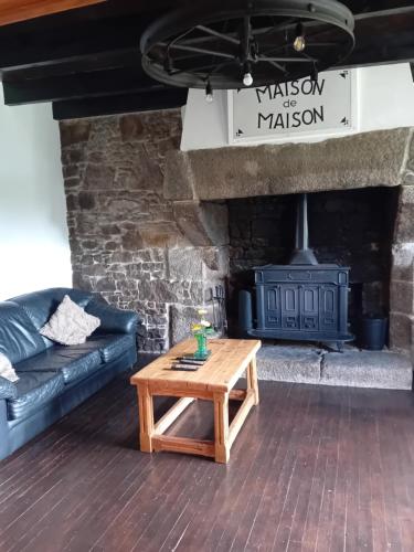 a living room with a couch and a fireplace at Maison de Maison in Maël-Pestivien