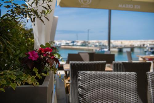 a restaurant with tables and chairs with flowers on them at Hotel Marina in Fažana