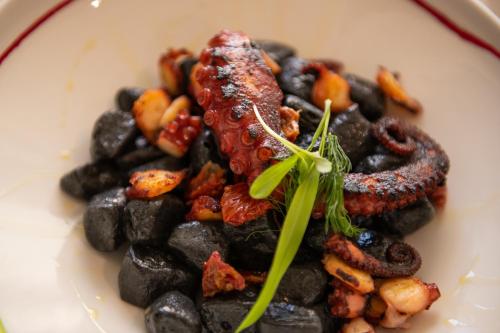 a plate of food with meat and rocks on it at Hotel Marina in Fažana