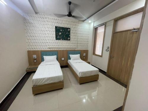a room with two beds in a room at Hotel Abhinandan Palace in Udaipur