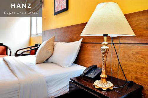 a lamp on a table next to a bed at HANZ Sai Gon Hotel Bui Vien Alley 40 in Ho Chi Minh City