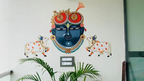 a wall with a statue of a head and two cows at Hotel Abhinandan Palace in Udaipur
