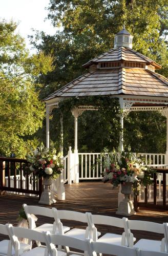 a wooden deck with a gazebo with white chairs at Fairview Inn in Jackson
